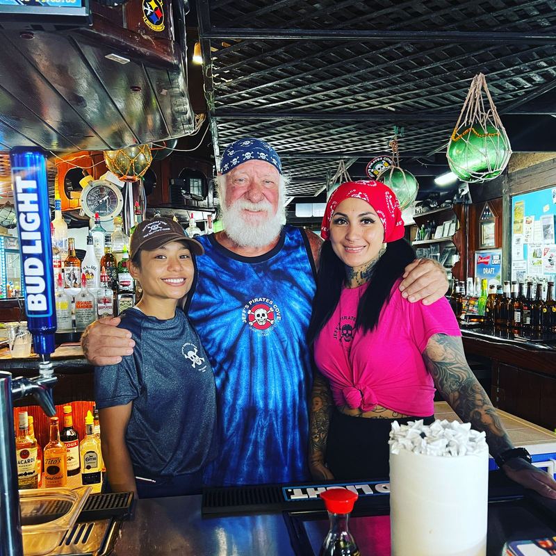Jeff Pleadwell, white beard and skull bandana, with two of his crew behind the Ship's Bar