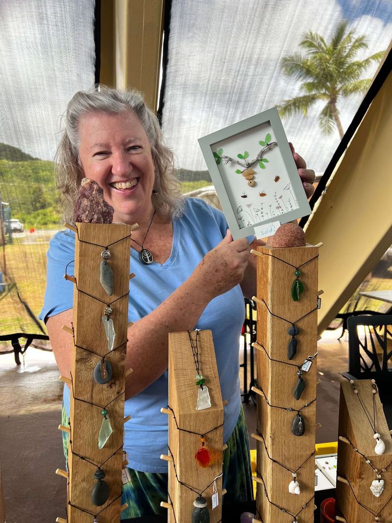 A local artisan holding up her handmade sea-glass art
