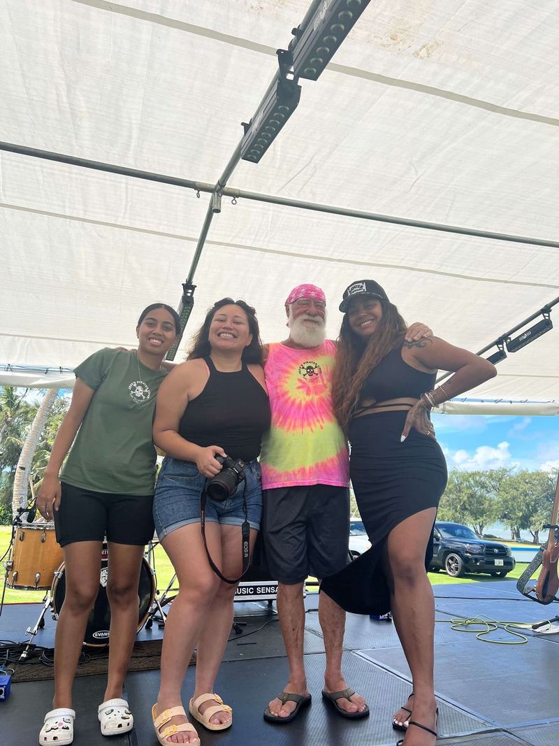 Captain Jeff in a tie-dye tee with guests on the outdoor stage