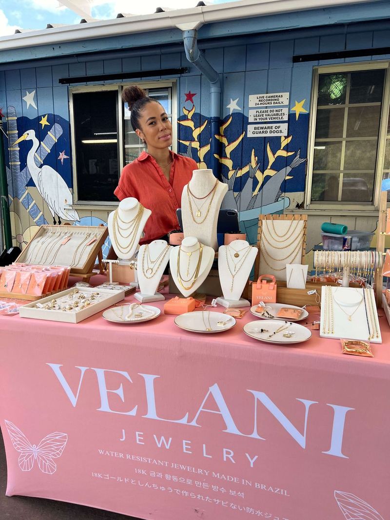 A jewelry vendor at her table at a Cove market day