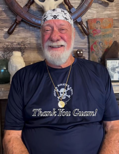 Jeff in a navy Jeff's Pirates Cove shirt and skull bandana, with the words Thank You Guam!