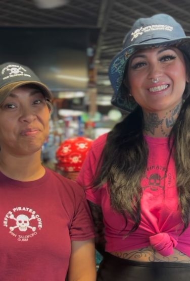 Two smiling crew members in Jeff's Pirates Cove shirts