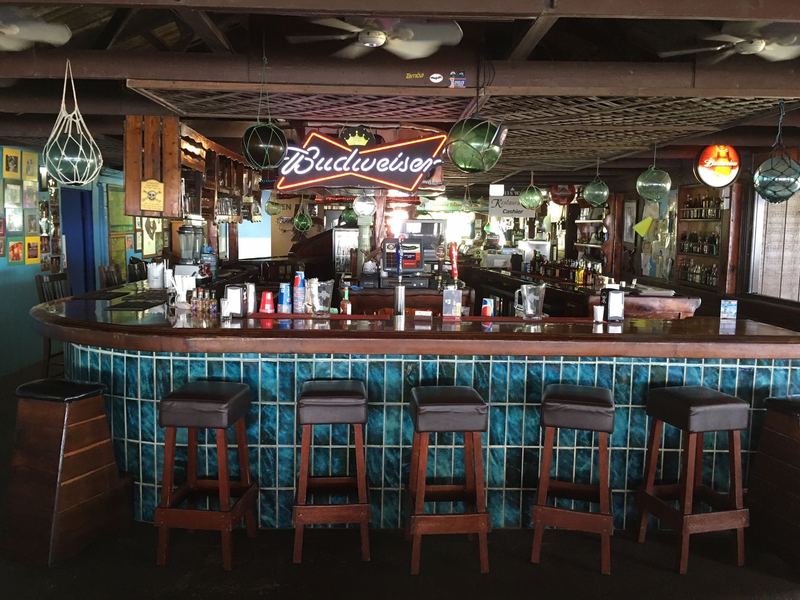 The Ship's Bar: turquoise tile bar front, stools, and hanging glass floats