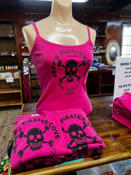 Hot pink skull tank tops, one on a mannequin and more folded on the counter
