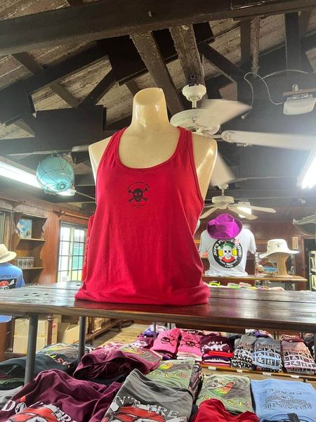 A red JPC tank top on a mannequin above tables of folded shirts