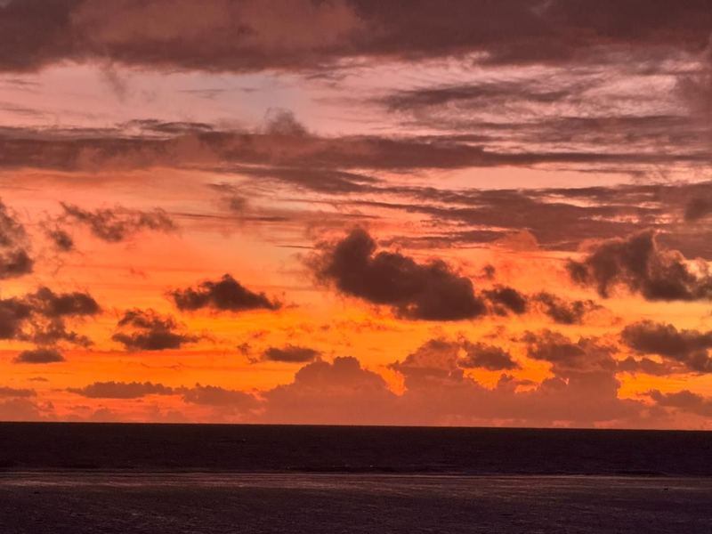 A red and orange east-coast sunrise over the Pacific, seen from the Cove