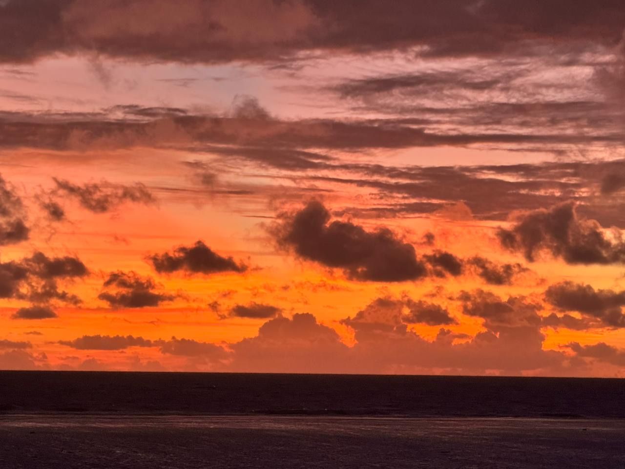 A red and orange east-coast sunrise over the Pacific, seen from the Cove