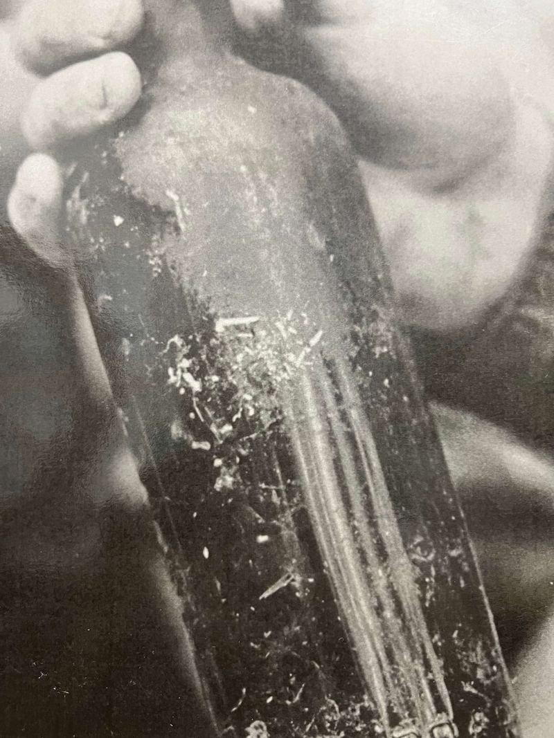 A hand holding a scratched, handmade canteen
