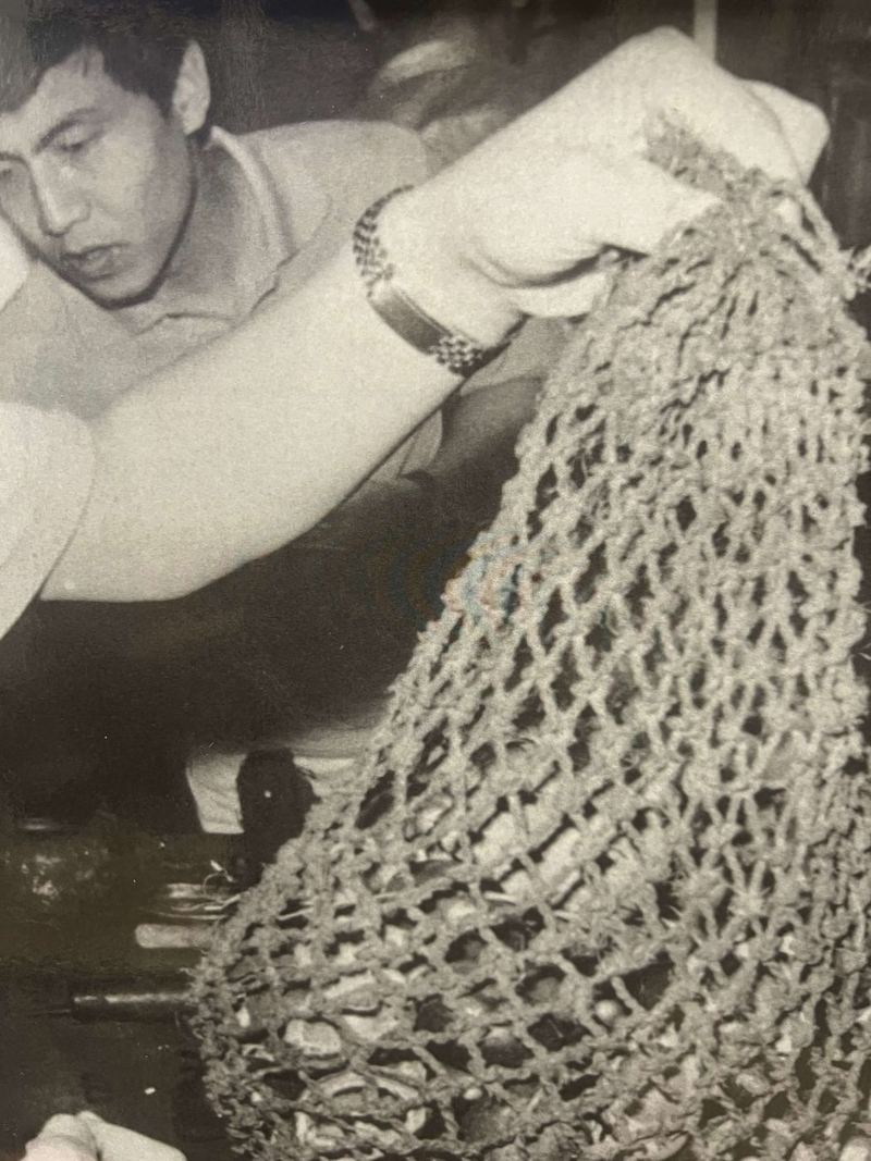 A man looking closely at a handwoven fiber garment